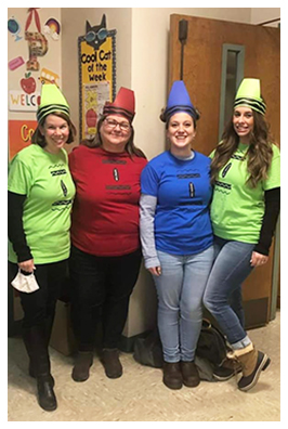 Four teachers dressed in colorful costumes